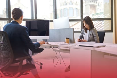 zwei geschäftsleute sitzen sich im Büro gegenüber und arbeiten